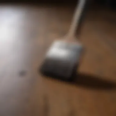 Close-up of brush and paint can on wooden floor